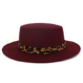 Detalle de sombrero plano de lana burdeos con elegante correa de leopardo y tachuela. - Ajustable / Burdeos