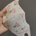Vue detaillee du masque de protection solaire 3D respirant avec motif floral et yeux proteges. - Rose