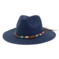 Vue détaillée du chapeau de paille bleu marine avec cordon tressé marron et pierres colorées. - Bleu Marine