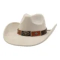 Detail view of a beige faux suede cowboy hat with brown leather band and bull skull decor. - Beige