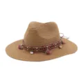 Detailed view of the woven straw sun hat featuring a colorful ethnic ribbon, tassels, and shell accents. - Khaki