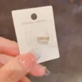 Detailaufnahme einer glitzernden zweireihigen Strass-Ohrklemme auf weißer Präsentationskarte. - Zirkon-Linie Ear Cuff (4#)