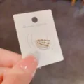 Detailansicht der eleganten minimalistischen Ohrklemme mit glänzenden Steinen auf Karte. - Gold Dreischicht Ear Cuff (9#)