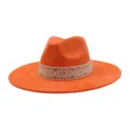 Detailopname van de helderoranje suède fedora hoed met een stijlvolle geweven band. - M (56-58cm) / Oranje