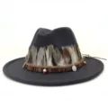 Vista detallada del sombrero fedora de lana gris oscuro con pluma etnica y cinta con dijes. - 58cm / Gris oscuro