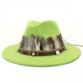 Detalle en primer plano del sombrero fedora de lana verde con plumas étnicas y dijes metálicos. - 58cm / Verde Fruta