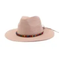 Détail de chapeau de paille rose avec bande de perles colorées et texture tissée estivale. - Rose