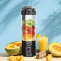 Dettaglio tazza frullatore di succo elettrico portatile, trasparente con frutta. - Nero