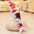 Closeup of realistic koi fish plush toy pillow, shown in a cozy home room setting. - Red, Yellow, and Black on White Base / 16cm