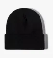 Solid color knit beanie detail view, showing cuffed winter warm hat structure clearly. - Black