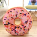Soft plush donut throw pillow with colorful sprinkle print, cozy home decoration detail. - Gone with the Wind