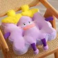 Cuscino per sedia in peluche viola con simpatico viso di cartone animato e capelli soffici. - Viola
