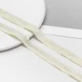 Dettaglio di nastro con pon pon crema, ideale per vestiti per bambole fai da te e decorazioni. - Confezione da 2 Metri / Beige