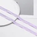 Primo piano dettagliato della passamaneria con pon pon viola chiaro, perfetta per il cucito. - Confezione da 2 Metri / Viola chiaro