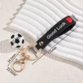 Mini football keychain sports fan bag pendant with silicone strap and metal ring. - Heart Strap Soccer (Black Rope)