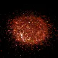 Detailed close-up view of shimmering red hexagonal nail glitter powder for crafts and art. - Laser Orange Hexagonal Iridescent Sequins
