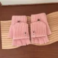 Vue détaillée de gants tricotés roses sans doigts avec rabats et boutons mignons. - Taille unique / Rose