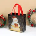 Bolsa de Navidad de tela no tejida gruesa con muñeco de nieve y asas rojas para regalos festivos. - Muñeco de Nieve / 22x23x11cm