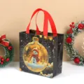 Vista detallada de bolsa de regalo navideña de tela no tejida negra con muñeco de nieve y asas. - Luz de muñeco de nieve / 22x23x11cm