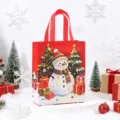 Red Christmas non-woven gift tote bag featuring cute snowman and festive tree design for holidays. - Snowman / 26x32x10cm