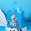 Detailed view of blue non-woven gift bag featuring cute cartoon unicorn and sturdy handles. - Light Blue
