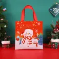 Bolsa de regalo navideña de tela roja con lindo muñeco de nieve, vista frontal para fiestas. - Campo de nieve rojo