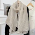 Vista dettagliata di una sciarpa beige spiegazzata con delicato bordo in pizzo, stile accogliente. - 180cm / Lino