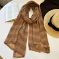 Detailed view of women autumn brown plaid scarf, cotton linen texture, elegant literary style. - Turmeric