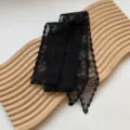 Primo piano dettagliato del nastro per capelli in pizzo nero, morbida texture floreale. - Nero