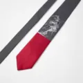 Close-up detail of the designer black and red striped tie featuring unique graphic print. - Rainy Night Duel