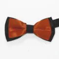 Primer plano detallado del pajarita doble naranja y negra con textura de tela limpia y fina. - Rojo