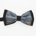 Detail shot of a black and grey bow tie featuring decorative metal corners for formal wear. - Gray