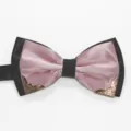 Close-up of pink and black bow tie with vintage metal corner decor for men's formal suit. - Pink