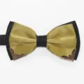 Closeup of a stylish mens black and gold bow tie featuring exquisite metallic decorative corner tips. - Pale Gold