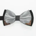 Detail view of a black and silver double layer bow tie featuring stylish bronze metal corner accents. - Light Gray