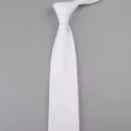 Vista dettagliata di una cravatta lavorata a maglia bianca, con punta classica e trama fine. - Bianco Puro