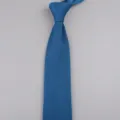 Primo piano dettagliato della cravatta blu lavorata a maglia, punta classica e tessitura. - Blu Pavone