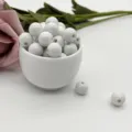 Closeup of white ceramic loose beads with drilled holes, perfect for DIY jewelry making and crafts. - 6mm / White