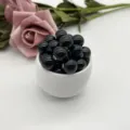 Detailed view of glossy black ceramic loose beads placed in a white cup, ideal for DIY jewelry crafting. - 6mm / Black