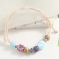 Fresh ceramic beaded bracelet, women woven cord seashell charm jewelry main product view. - Blue Shell and Cheese Purple