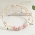 Minimalist handmade woven cord bracelet featuring charming pink and white ceramic beads. - Bodhi Pink Style