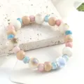 Bellissimo bracciale con perle in ceramica in colori pastello misti e ciondolo a fiore per l'uso. - Linguaggio dei fiori (ghiaccio blu)