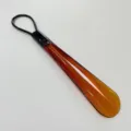 Bernsteinfarbener Kunststoff Schuhlöffel mit schwarzer Schlaufe für einfaches Anziehen - Transparentes Tee-Braun