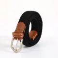 Black woven elastic belt with a brown leather end and silver pin buckle for daily wear. - Black
