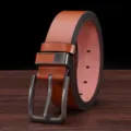 Close-up view of brown leather men's belt with alloy pin buckle on wooden table surface. - 115cm / Brown