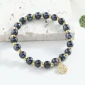 Elegant black bead and gold accent bracelet featuring an auspicious Fu pendant for women. - 6mm / Black
