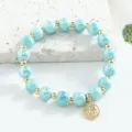 Bracelet en perles de ceramique bleu clair chic avec accents dores et pendentif. - 8mm / Aigue-marine
