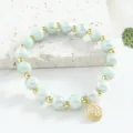 Bracelet en perles de céramique verte avec intercalaires dorés et pendentif porte-bonheur - 8mm / Vert Haricot