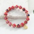 Bracelet de perles en céramique de Jingdezhen coloré avec charm doré et espaceurs. - 8mm / Rouge moucheté de noir