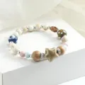 Bracciale di perle in ceramica fatto a mano con ciondolo a stella, gioiello etnico elastico. - Stella dell'orizzonte